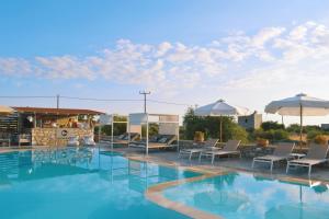 a pool at a hotel with chairs and umbrellas at Kastro Maini in Areopolis