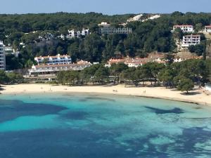 eine Luftansicht auf einen Strand mit Menschen im Wasser in der Unterkunft Galdana Gardens in Cala Galdana