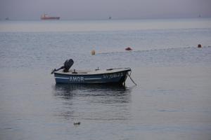 mała łódź siedząca na środku wody w obiekcie Hotel Beach Split w Podstranie