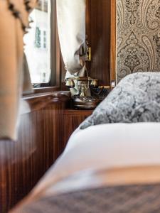 カンポ・ディ・トレンスにあるLuxury Lodge - Orient Express Lenerのベッドルーム1室(ベッド1台、窓、電話付)