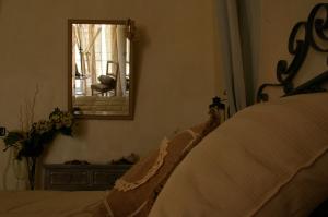 a bedroom with a bed and a mirror and a chair at Serapo Bed and Breakfast in Gaeta