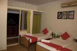 1 dormitorio con 2 camas y ventana en Nachis BNB, en Bangalore