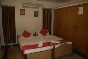 1 dormitorio con 2 camas y almohadas rojas en Nachis BNB, en Bangalore