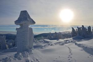 un pilier en pierre au sommet d'une montagne enneigée dans l'établissement Chata Jiriho na Seraku, à Bělá pod Pradědem