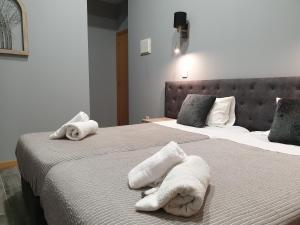 a bedroom with two beds with towels on them at Leao de Ouro in Matosinhos