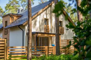 a house with a fence and trees in front of it at Villa Arkadia in Łukęcin