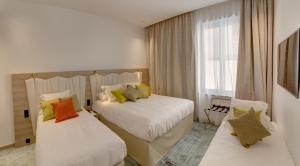 A bed or beds in a room at Best Western Plus Comedie Saint Roch