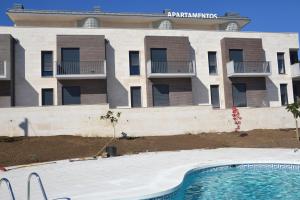 uma piscina vazia em frente a um edifício em Costa Quebrada Apartamentos em Soto de la Marina