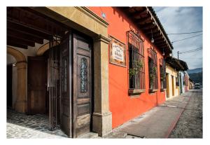 an orange building with a door on a street at Posada El Antaño in Antigua Guatemala