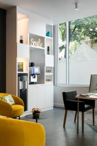 uma sala de estar com cadeiras amarelas e uma mesa em Citadines Place d'Italie Paris em Paris