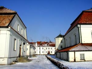 una fila di edifici bianchi con neve per terra di Apartament 'Aleks' Tykocin a Tykocin