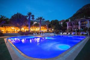 une grande piscine bleue en face d'une maison dans l'établissement Club Pink Palace Hotel, à Ölüdeniz