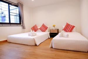 two white beds in a room with a window at Lisa'House in Bangkok