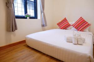 a bedroom with a white bed with two pillows at Lisa'House in Bangkok