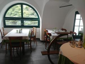 un comedor con mesas y sillas y una ventana en Hotel garni Paleta, en Škofja Loka