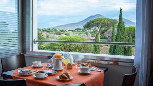 un tavolo con cibo e una finestra con vista di Hotel del Sole a Pompei