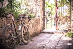 un vélo garé à côté d'un mur en pierre dans l'établissement Agriturismo Li Calizzi Arte e Natura, à Novoli