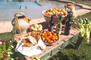 - une table avec des paniers de fruits et des bouteilles de vin dans l'établissement Agriturismo Li Calizzi Arte e Natura, à Novoli