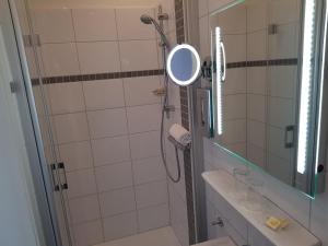 La salle de bains est pourvue d'une douche avec un miroir et un lavabo. dans l'établissement Hotel zum Anker, à Andernach