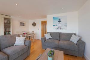 Sala de estar con 2 sofás y mesa en The Beach House & Porth Sands Apartments, en Newquay