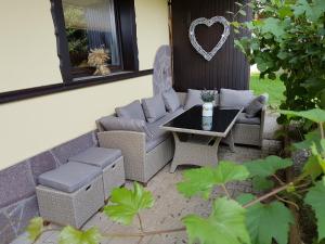 eine Terrasse mit einem Tisch, Stühlen und einer Bank in der Unterkunft Garden Apartments Maria in Bled