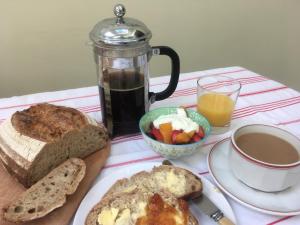 einen Tisch mit einem Teller Brot und einer Tasse Kaffee in der Unterkunft Old Station Gardens, SW London in Teddington