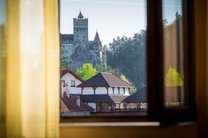 uma vista para um castelo a partir de uma janela em Hanul Bran em Bran