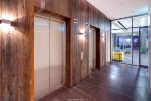 un couloir de bureau avec des murs en bois et des portes en verre dans l'établissement Zara Tower – Luxury Suites and Apartments, à Sydney