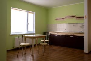 a kitchen with a table and chairs and a window at Hotel Complex Olimp in Umanʼ