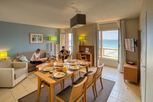 - un salon avec une table et des fauteuils dans l'établissement Residence Reine Marine, à Saint-Malo