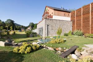 un jardin avec un bâtiment en pierre et une maison dans l'établissement Peras Wellness Hotel, à Ludvíkov