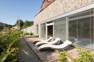 une rangée de bancs blancs assis à l'extérieur d'un bâtiment dans l'établissement Peras Wellness Hotel, à Ludvíkov