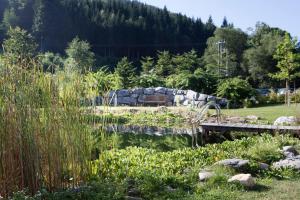 un jardin avec un étang et un mur en pierre dans l'établissement Peras Wellness Hotel, à Ludvíkov