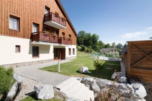 une maison avec un balcon et une cour ornée de rochers dans l'établissement Peras Wellness Hotel, à Ludvíkov