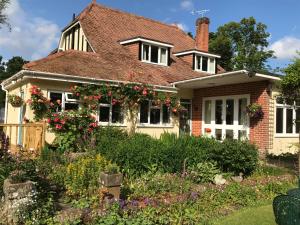 een huis met een tuin ervoor bij Kingswood Cottage in Lyndhurst