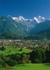 une ville dans une vallée avec des montagnes enneigées dans l'établissement Hotel Blume Interlaken, à Interlaken