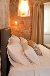 a bed with white sheets and pillows in a room at Villa Teuta in Trogir