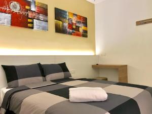 a bedroom with a bed with two paintings on the wall at RIVERO BOUTIQUE HOTEL Seremban 2 in Seremban