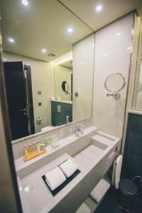 bagno con lavandino e grande specchio di Louis V Hotel Beirut a Beirut