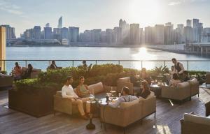 eine Gruppe von Menschen, die auf dem Dach eines Gebäudes sitzen in der Unterkunft Four Seasons Hotel Abu Dhabi at Al Maryah Island in Abu Dhabi