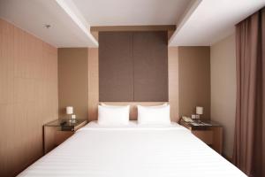 1 dormitorio con 1 cama grande y 2 mesitas de noche en Swiss-Belinn Airport Jakarta, en Tangerang