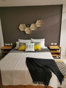 a bedroom with a large bed with yellow and white pillows at Kapital Suites in Pereira