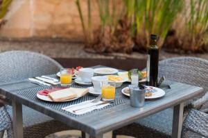 een picknicktafel met eten en een fles wijn bij Alcudia Petit - Turismo de Interior in Alcudia