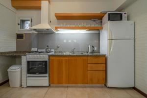 uma cozinha com um frigorífico branco e um lavatório em Valeria House Rental Suites em Valeria del Mar