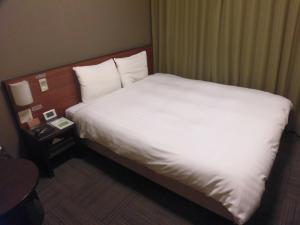 Una cama o camas en una habitación de Dormy Inn Asahikawa