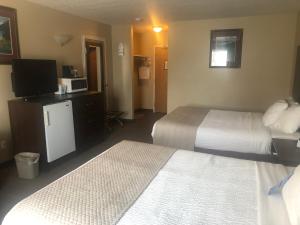 ein Hotelzimmer mit 2 Betten und einem TV in der Unterkunft Days Inn by Wyndham Hinton in Hinton