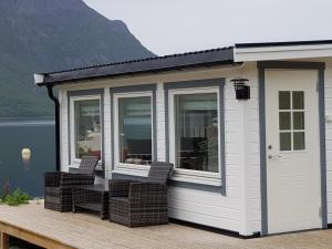 a large white shed with two chairs on a deck at Captains Small House in Hamneide