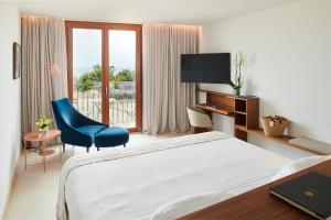 ein Hotelzimmer mit einem Bett, einem Schreibtisch und einem TV in der Unterkunft Es Princep - The Leading Hotels of the World in Palma de Mallorca