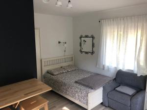 - une petite chambre avec un lit et une chaise dans l'établissement Apartments Nuna, à Krapinske Toplice