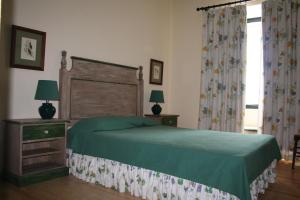 um quarto com uma cama verde e uma janela em Casa da Arvore em Marvão